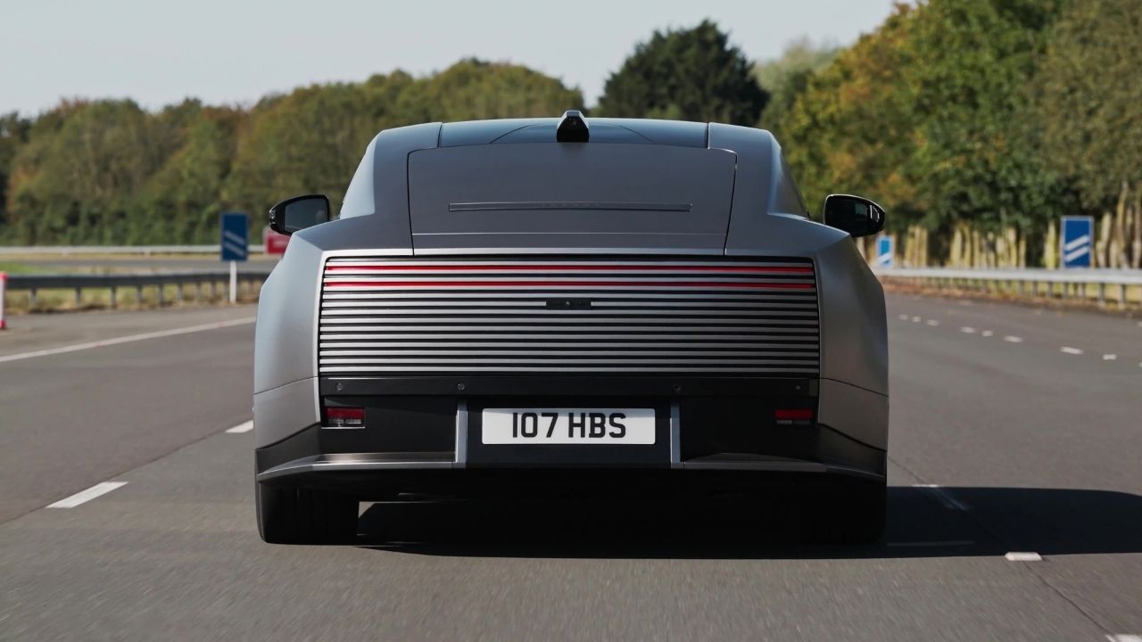 Jaguar Type 01 rear view showing its hidden tail lights, driving on road