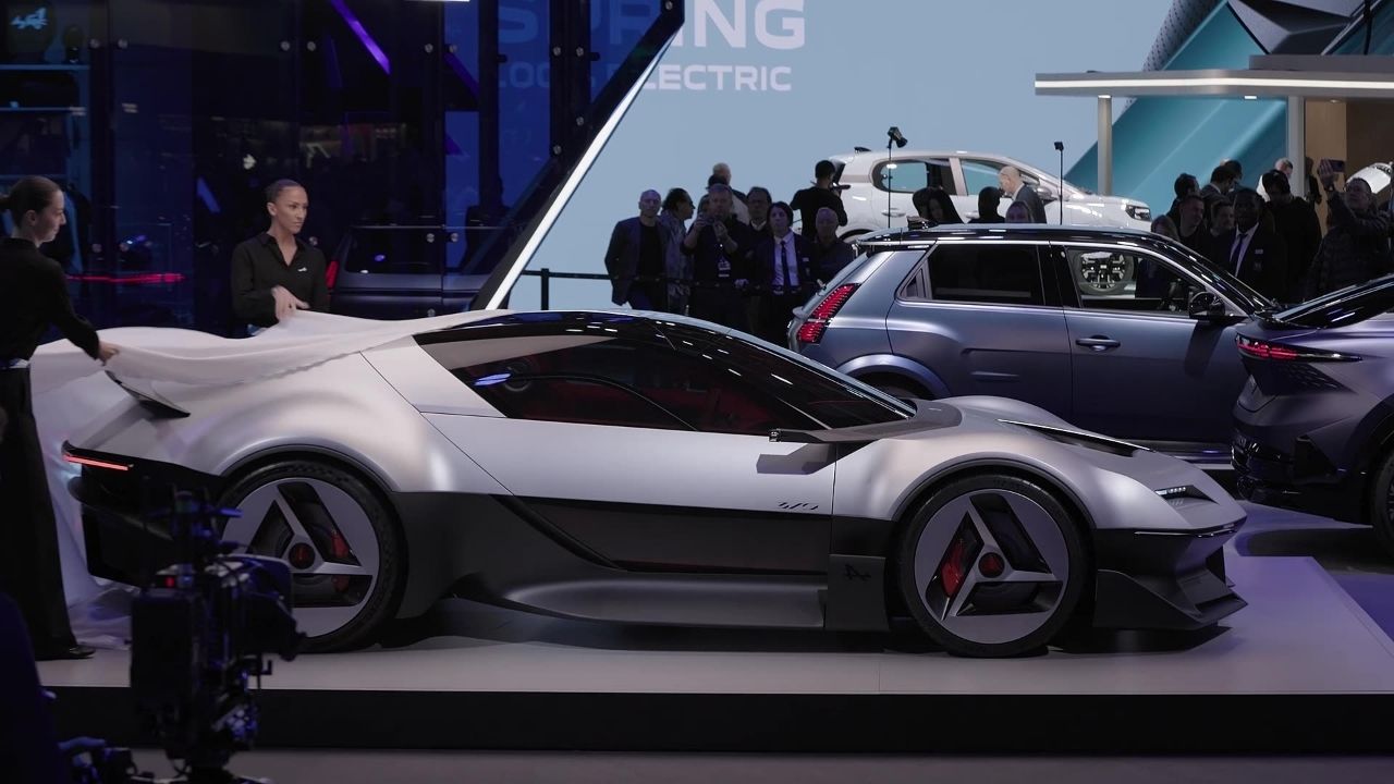 Silver Alpine A310 Vision concept being unveiled on the Alpine stand at Paris Motor Show 2026, shown in side profile with its A-shaped wheels