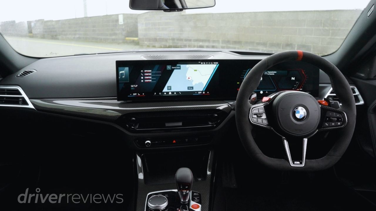 BMW M2 CS interior showing M steering wheel with configuration buttons, dual digital displays and carbon fibre trim