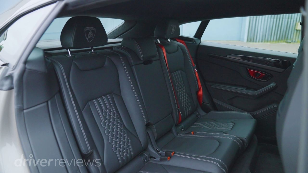 Lamborghini Urus SE rear seats showing three-seat bench with Lamborghini headrest embroidery and red seatbelts