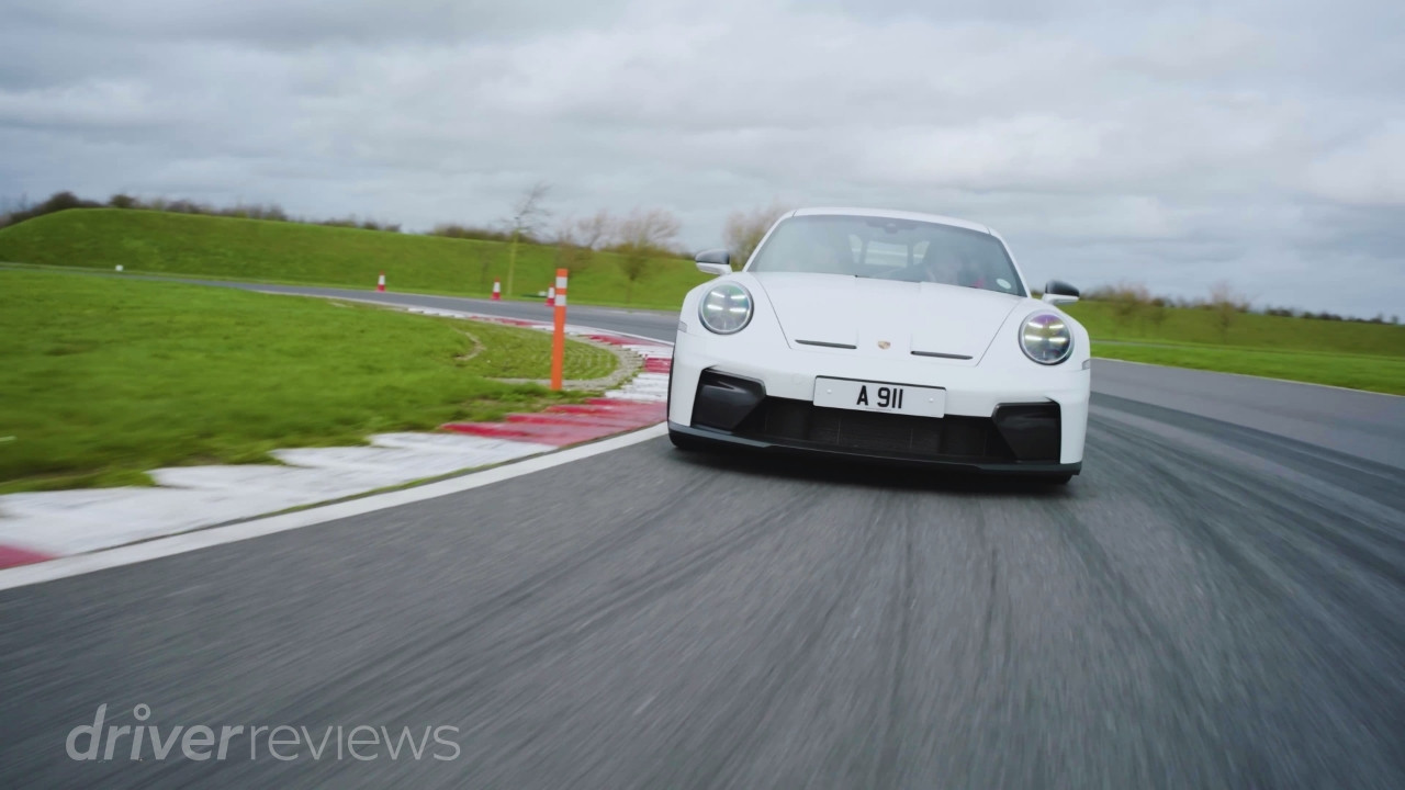 Porsche 911 GT3 992.2 on track approaching corner at speed during DriverReviews test