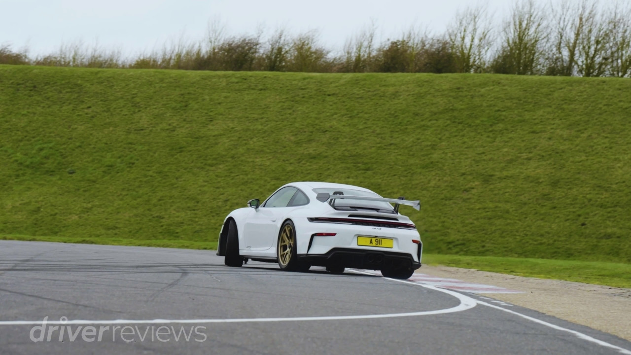 Porsche 911 GT3 992.2 cornering on track rear three-quarter view during DriverReviews test