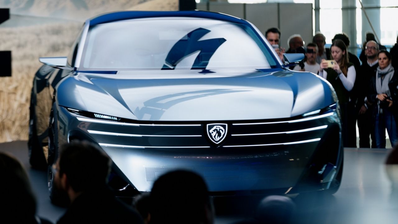 Silver Peugeot RCZ Vision concept with horizontal light bars on the Peugeot stand at Paris Motor Show 2026, shown head-on as visitors take photos