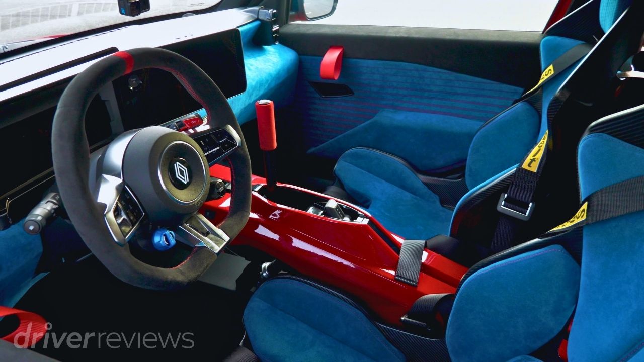 Renault 5 Turbo 3E interior showing blue bucket seats and six-point harnesses