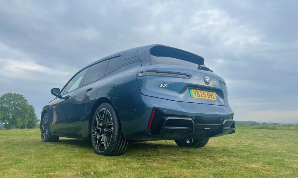 Rear exterior image of the BMW iX stationary in a field