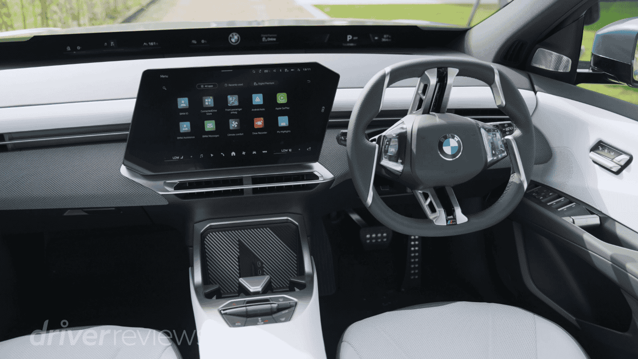 BMW iX3 interior with Panoramic iDrive screen showing BMW OS X app grid in light interior