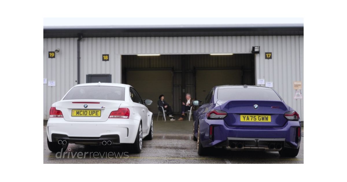 BMW 1M and BMW M2 CS rear view side by side at circuit with Vicki Butler-Henderson and Tiff Needell in background