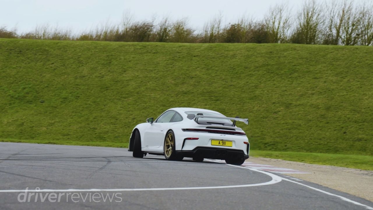 Porsche 911 GT3 992.2 cornering on track rear three-quarter view during DriverReviews test