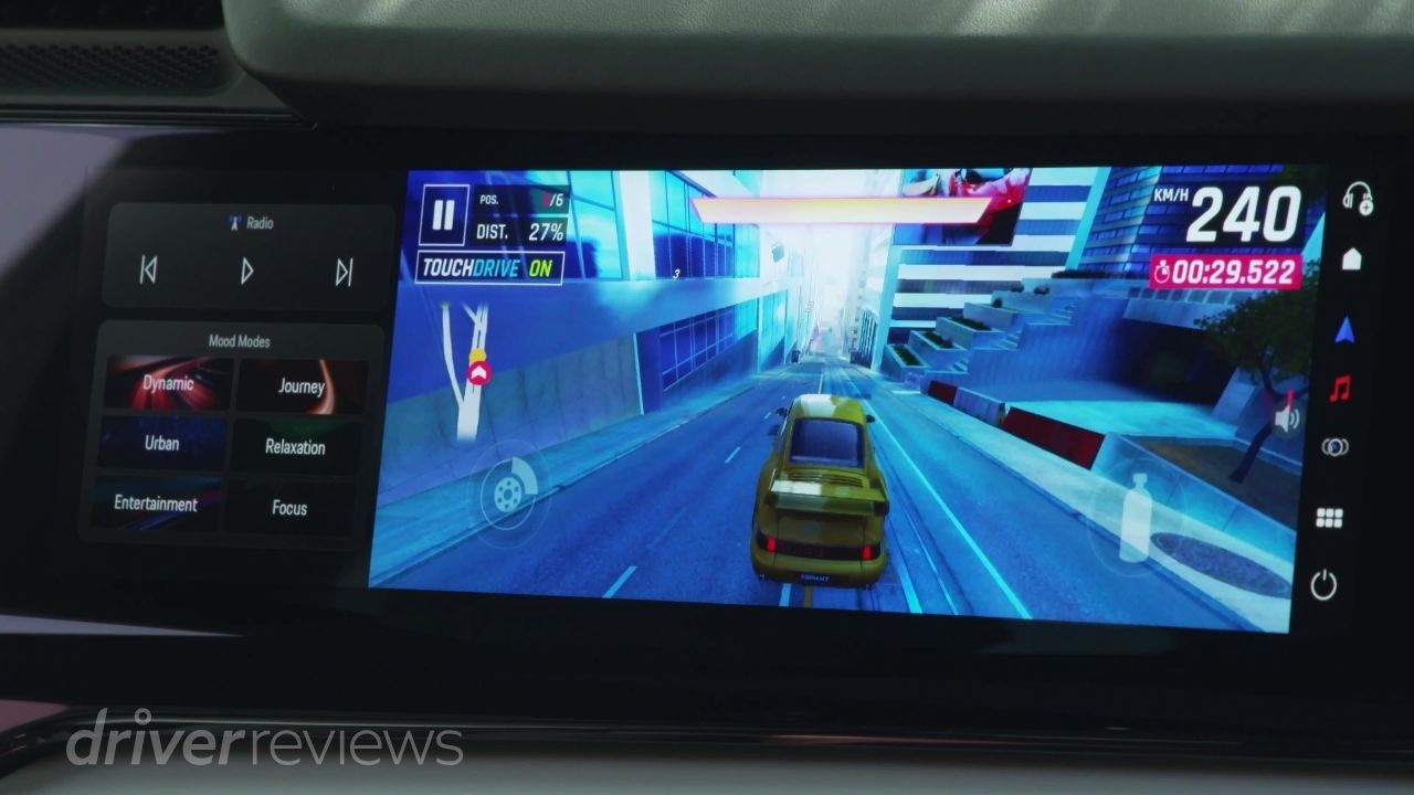Porsche Cayenne Turbo Electric passenger display showing Porsche 911 racing game with Mood Modes panel
