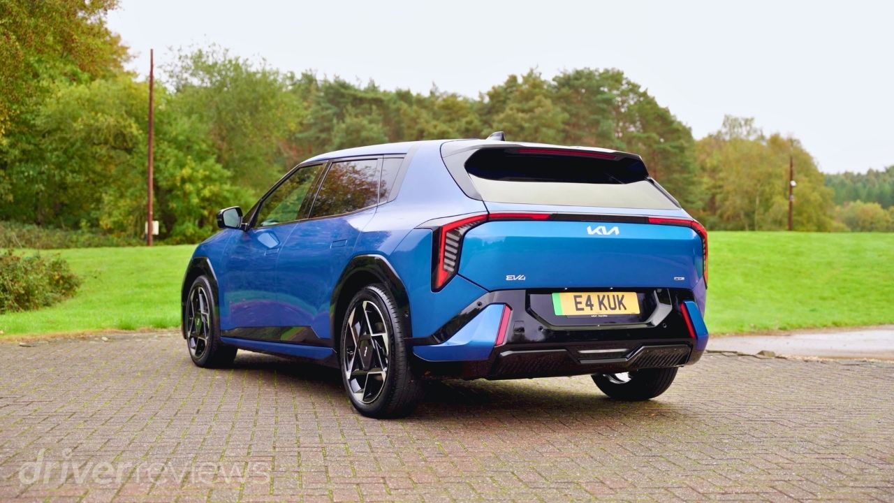 Rear three-quarter view of the 2026 Kia EV4 GT-Line S in Blue Flame showing its LED tail lights and roof spoiler