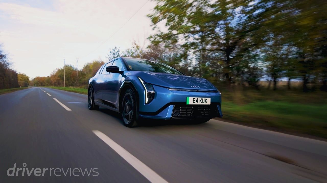 2026 Kia EV4 GT-Line S driving on a UK country road in Blue Flame