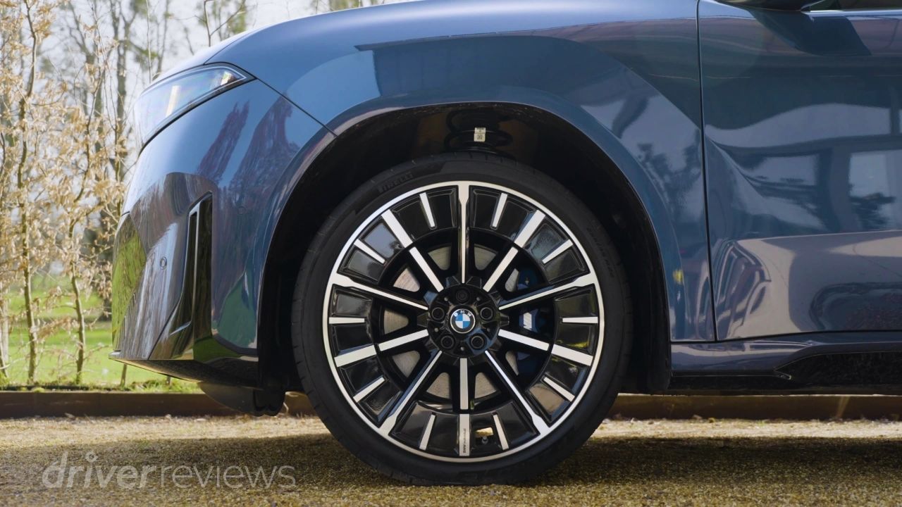 BMW iX3 multi-spoke alloy wheel close-up in dark blue metallic at DriverReviews test