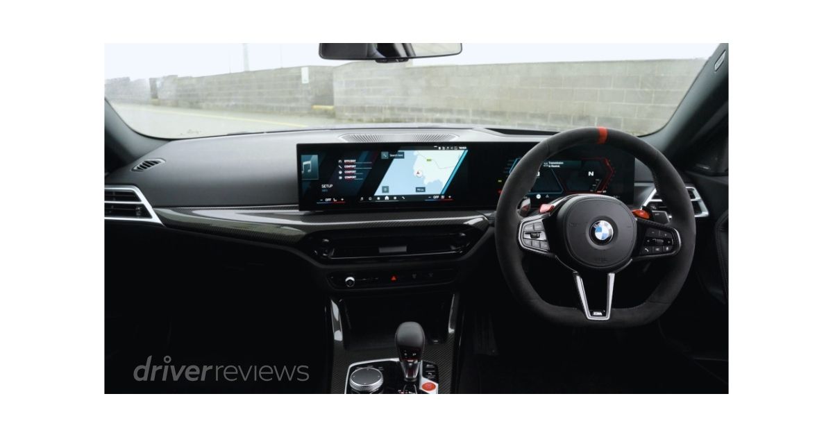 BMW M2 CS interior showing M steering wheel with configuration buttons, dual digital displays and carbon fibre trim