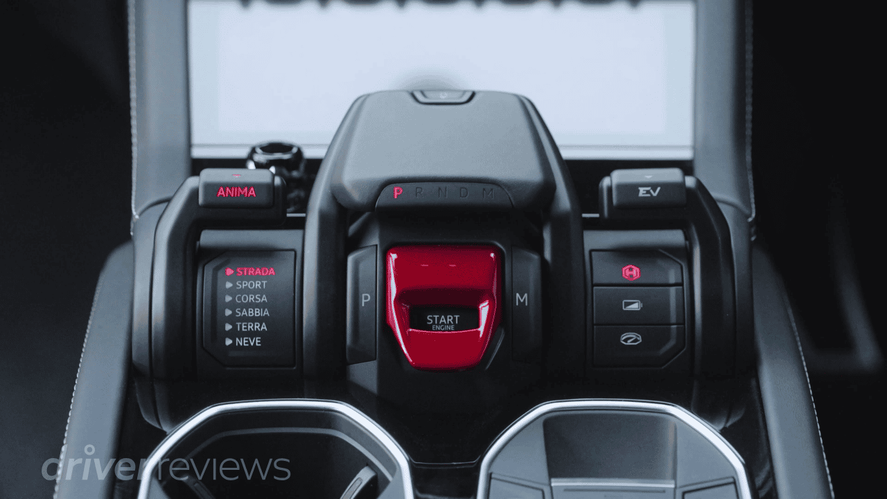 Lamborghini Urus SE Tamburo control centre showing red engine start flap, driving modes including Strada Sport Corsa Sabbia Terra Neve and EV button