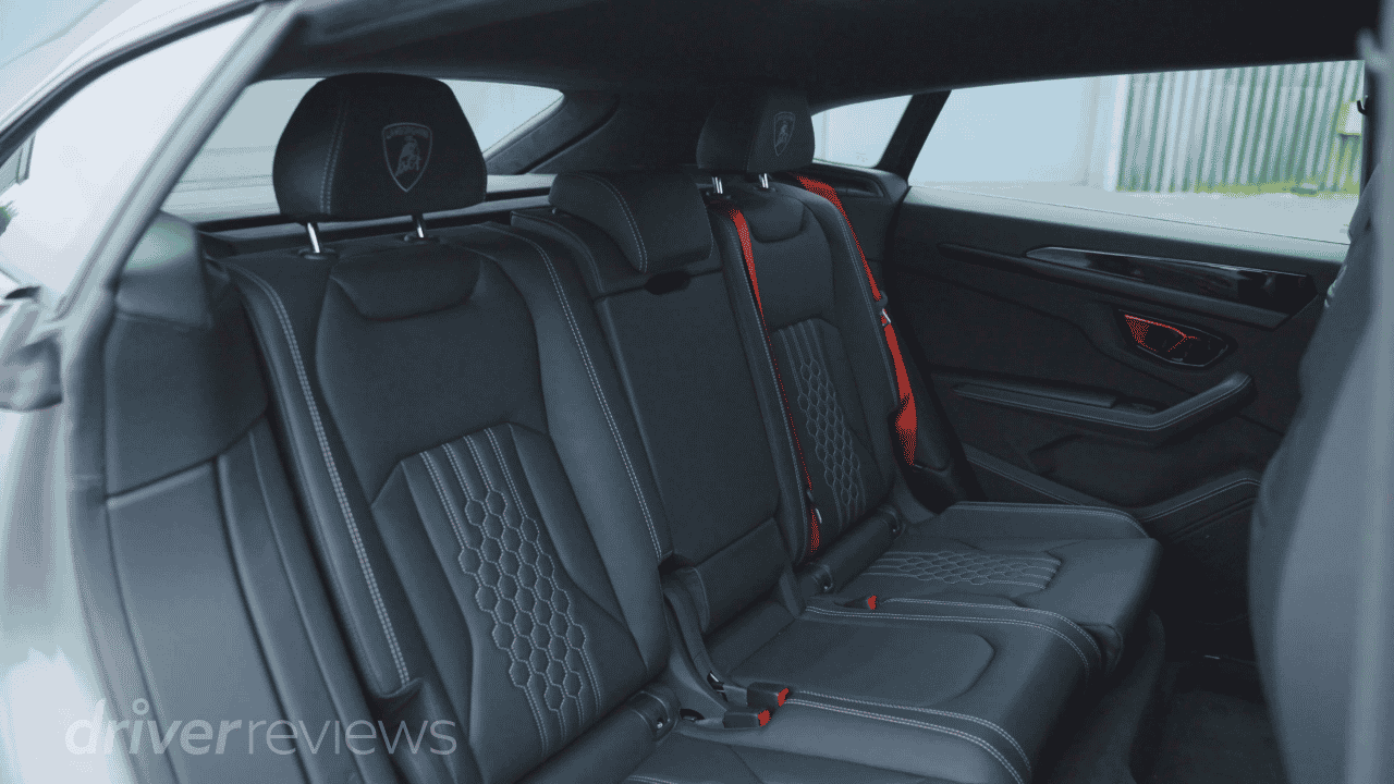 Lamborghini Urus SE rear seats showing three-seat bench with Lamborghini headrest embroidery and red seatbelts